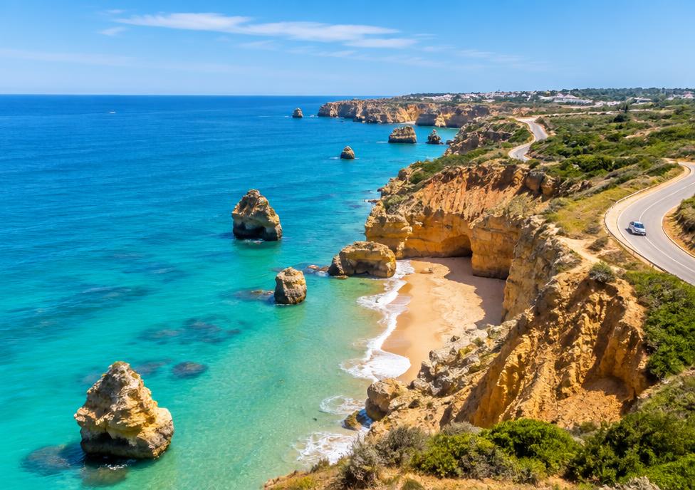 Coastal beach road in the Algarve with turquoise sea and cliffs